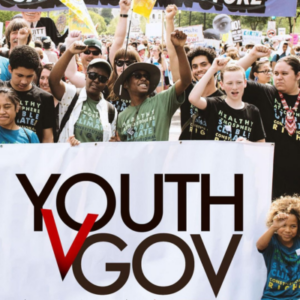 A diverse array of youth at a climate march. Text overlay reads Youth V Gov