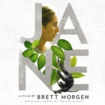 Detail from the film poster for JANE. The title is spelled out in bold silver letters, decorated with Jane Goodall's profile, tropical greenery, and a chimpanzee.