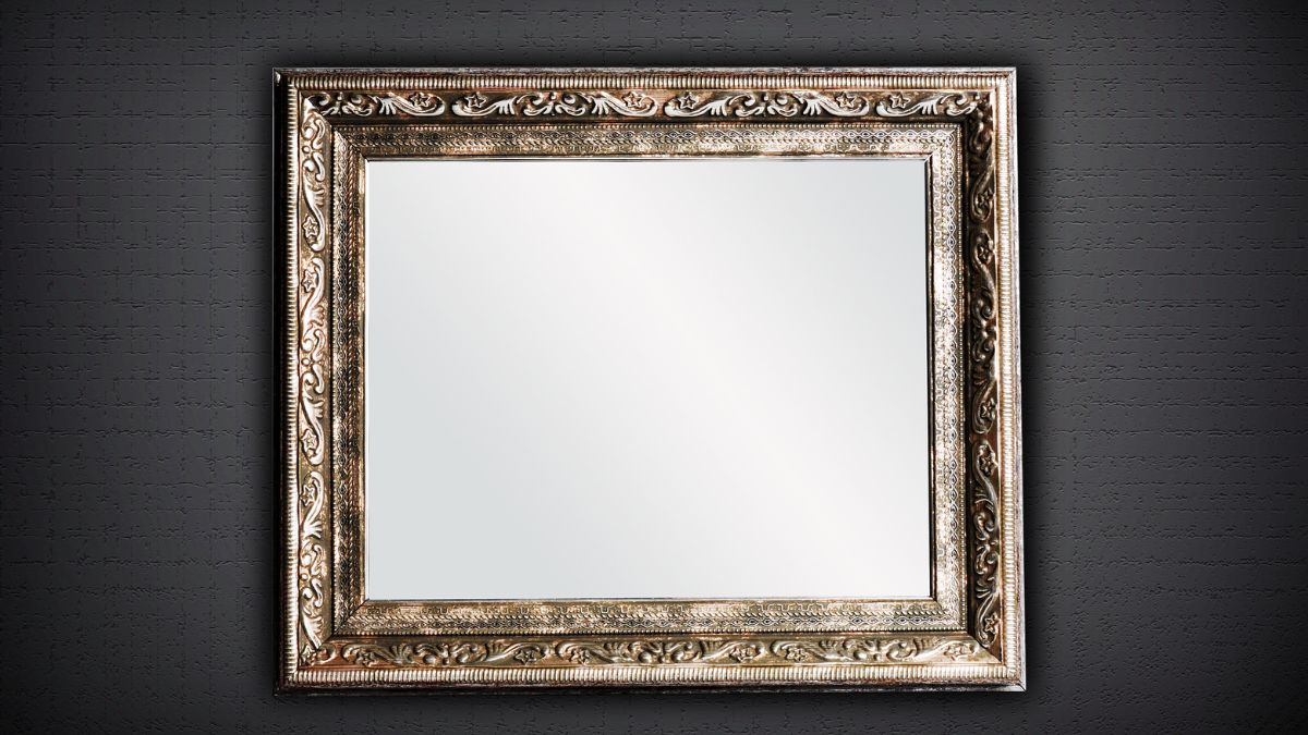 A large rectangular mirror in an ornate metal frame hangs on a dark grey wall. The image is sturdy and reassuring. 