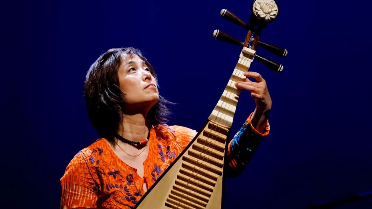 Chinese musician Wu Man performs the pipa, a string instrument, on stage. She is featured in the Silk Road American Railroad Project and the series My Music with Rhiannon Giddens.